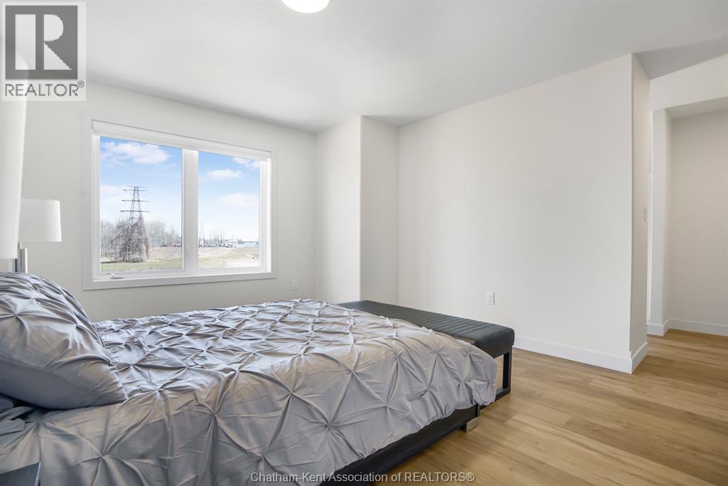 A bedroom with a large bed and a window overlooking a field.