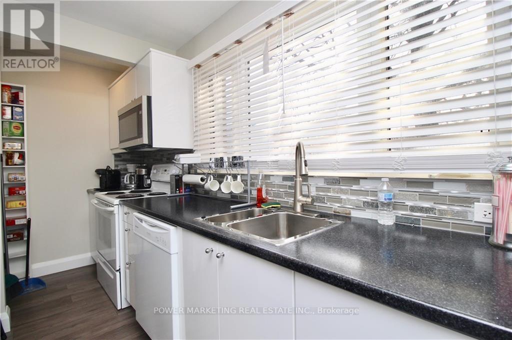 A kitchen with white cabinets and a black countertop.