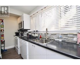 A kitchen with white cabinets and a black countertop.