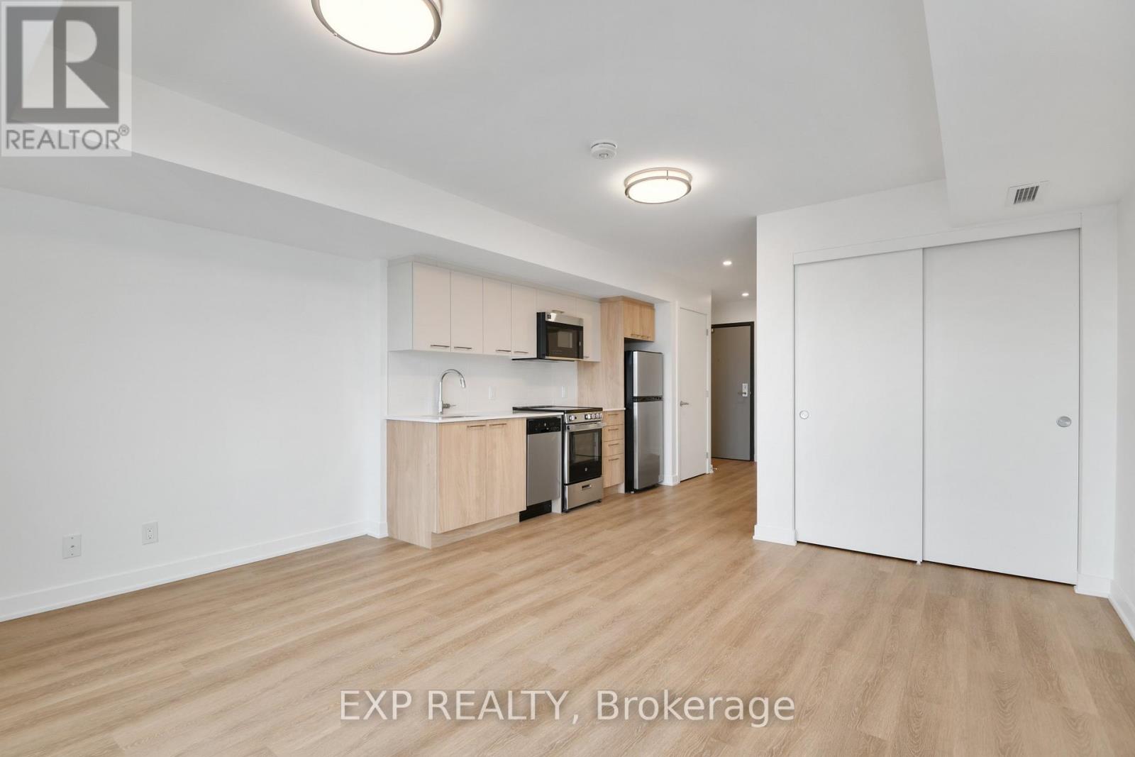 A well-lit, empty apartment with wooden floors and white walls is on the market.