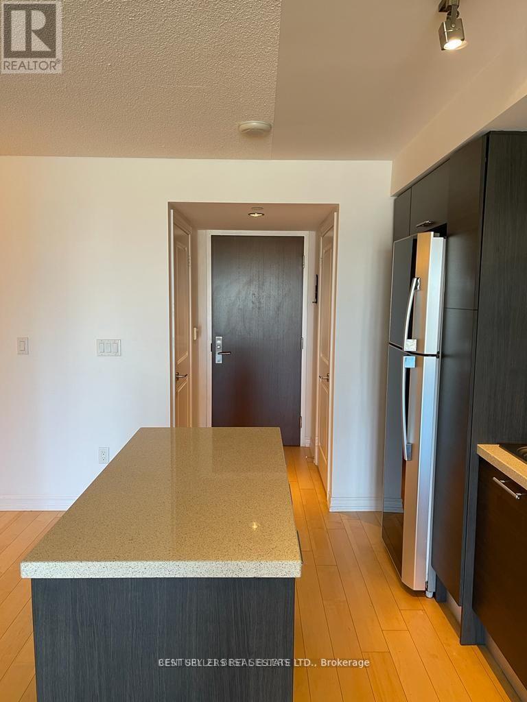 A kitchen with a granite counter top and a refrigerator.