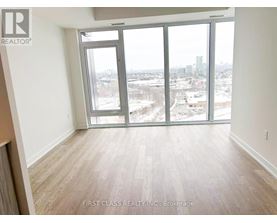 A room with a view of the city through large windows.