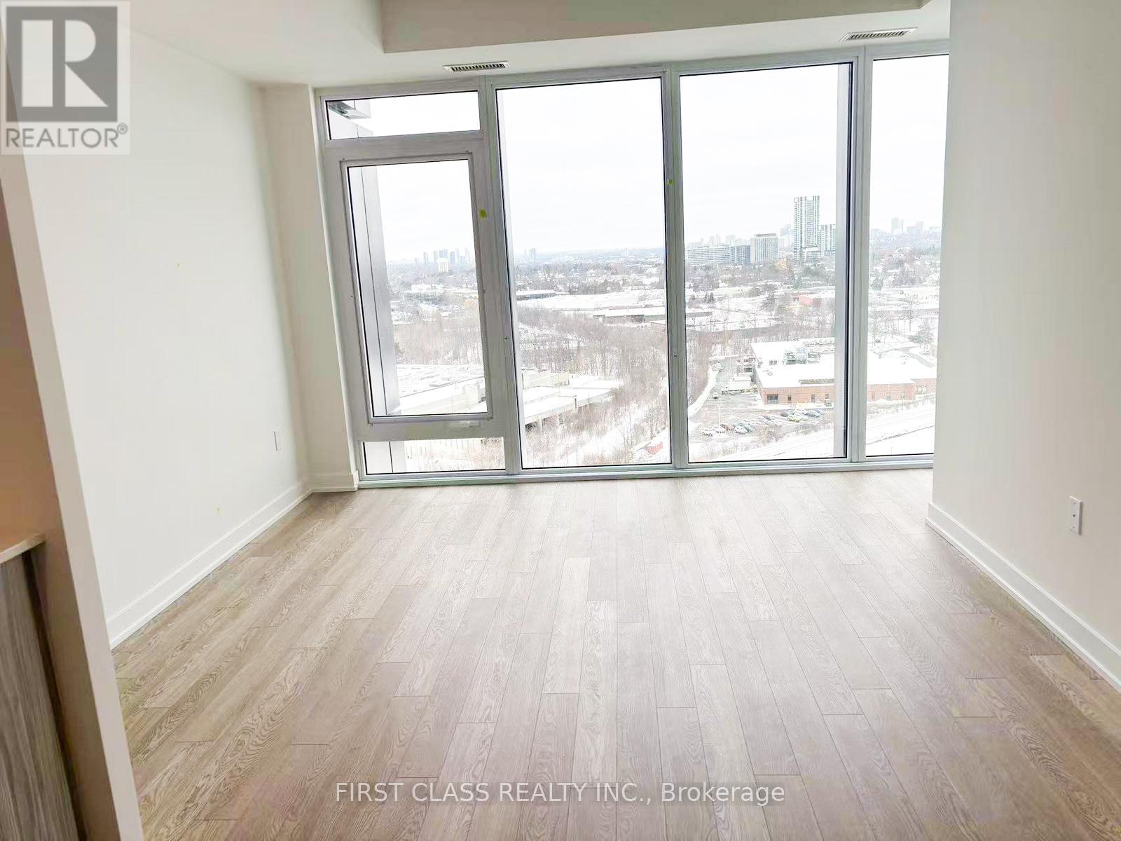 A room with a view of the city through large windows.