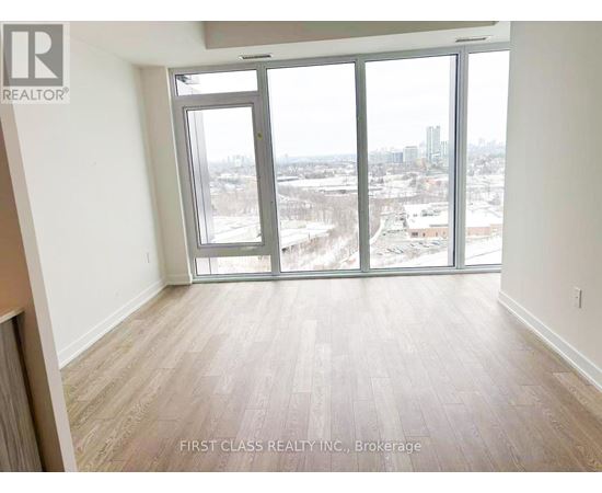 A room with a view of the city through large windows.