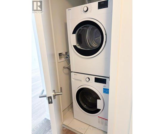 A washer and dryer combo is installed in a wall.