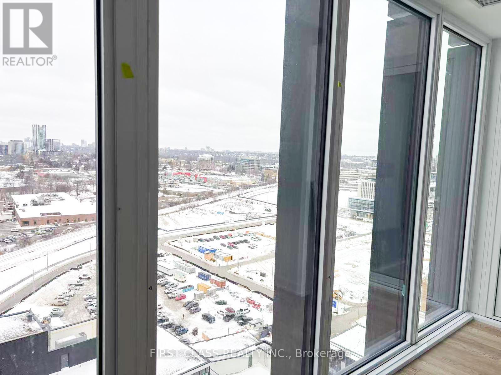 A view from a window looking out at a parking lot and buildings.