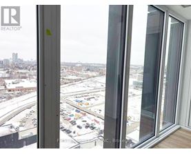 A view from a window looking out at a parking lot and buildings.