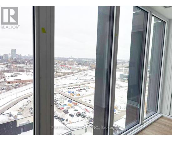 A view from a window looking out at a parking lot and buildings.