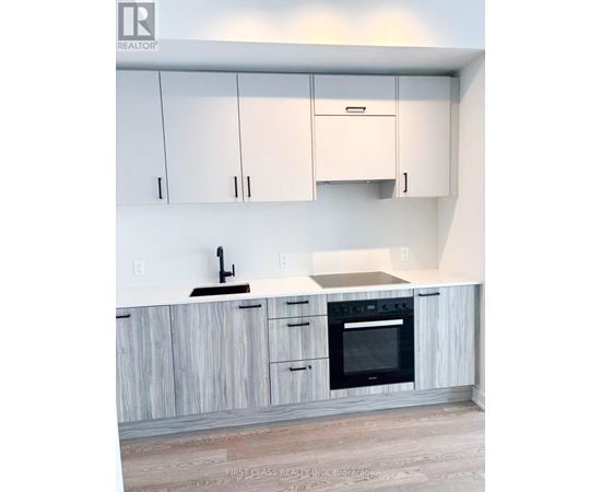 A kitchen with white cabinets and a wooden counter.
