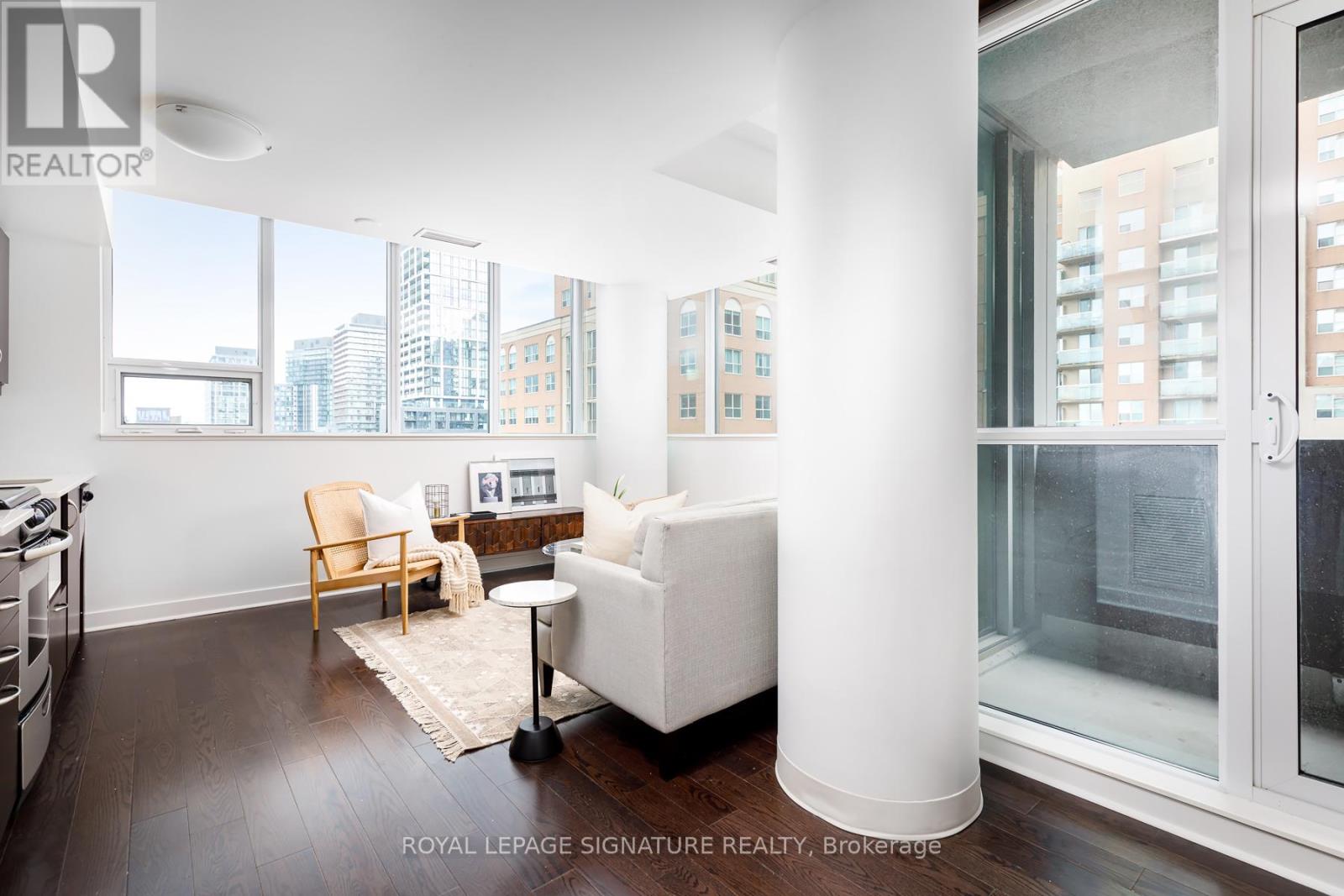 A modern living room with a white sofa and a view of the city.