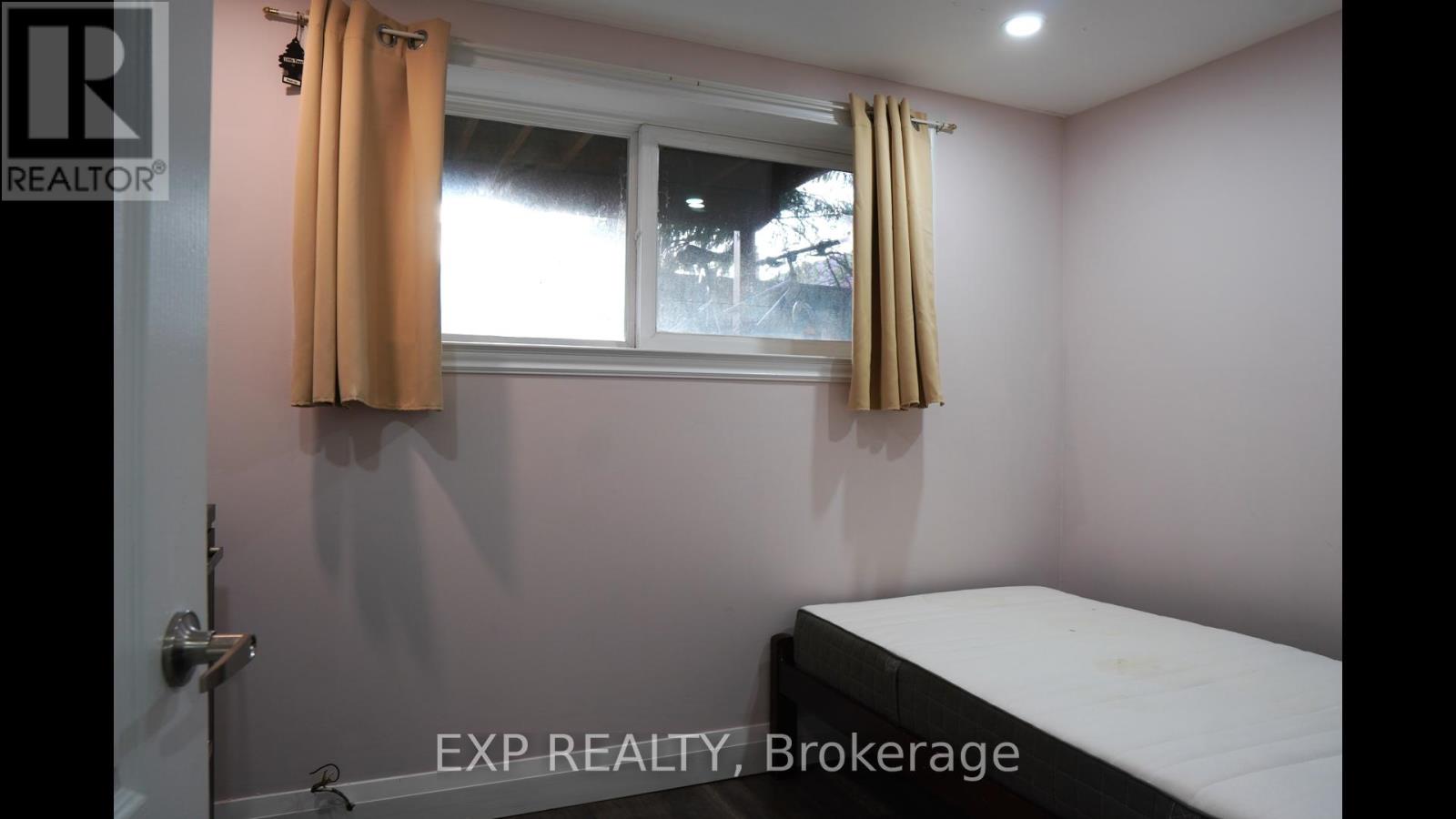A bedroom with a bed, window, and a door.