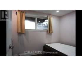 A bedroom with a bed, window, and a door.