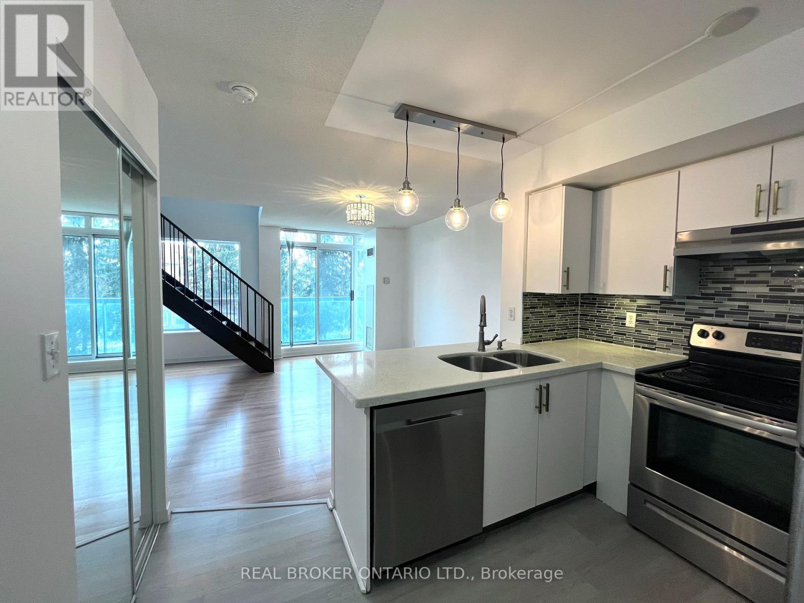 A modern kitchen with stainless steel appliances and white cabinets.