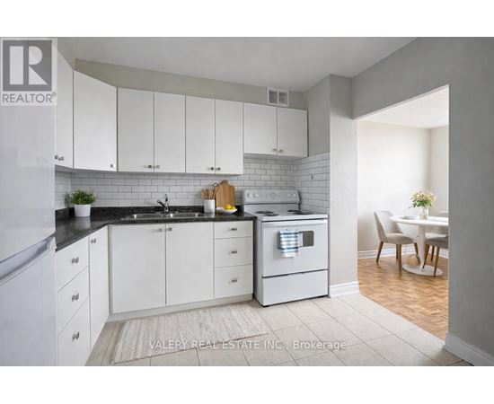 A kitchen with white cabinets and a black countertop.