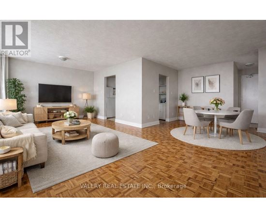 A living room with a wooden floor and a television on the wall.