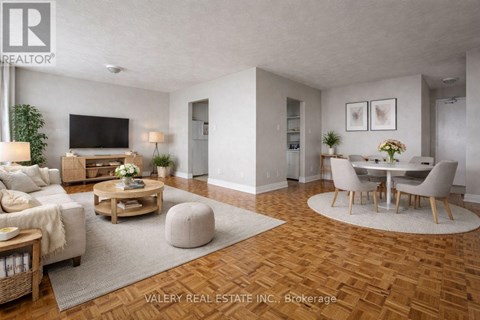 A living room with a wooden floor and a television on the wall.