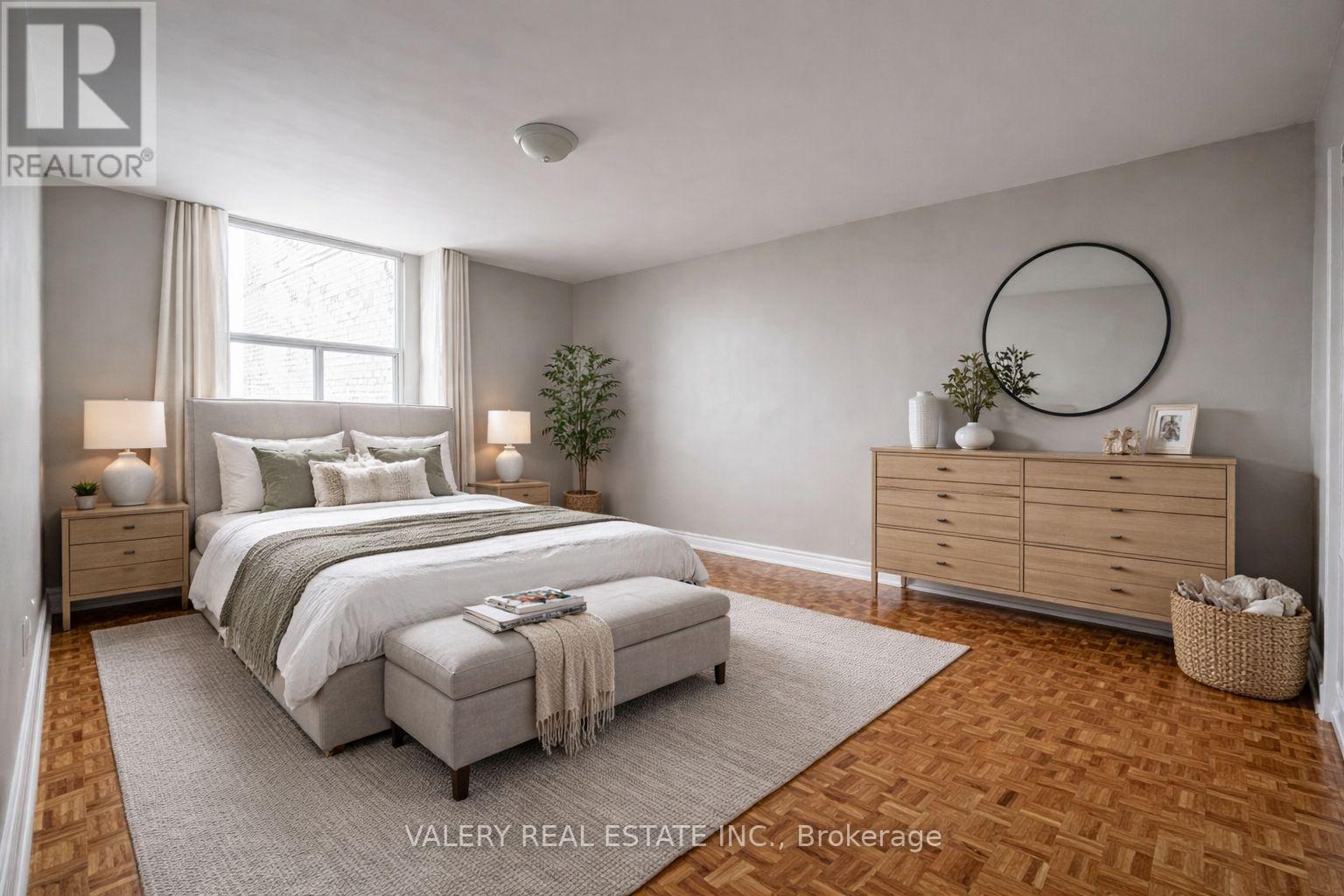 A bedroom with a large bed, a dresser, and a mirror.