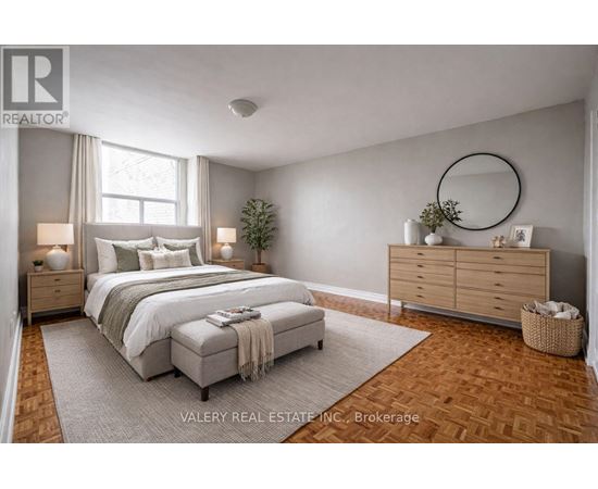 A bedroom with a large bed, a dresser, and a mirror.