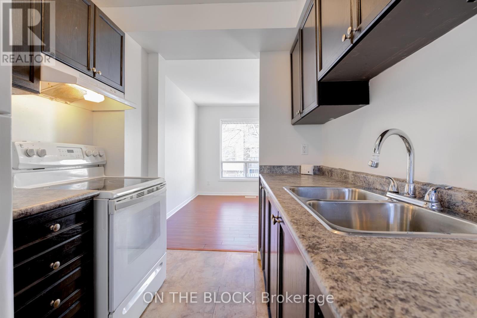A kitchen with a white oven and a sink.
