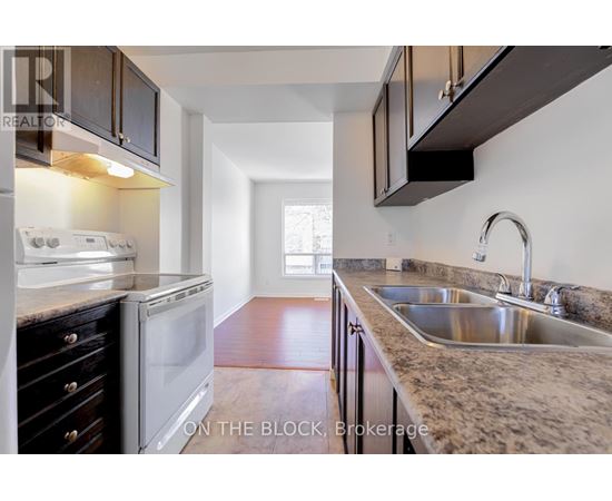 A kitchen with a white oven and a sink.