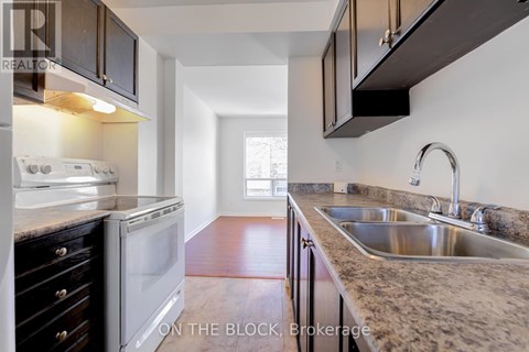 A kitchen with a white oven and a sink.