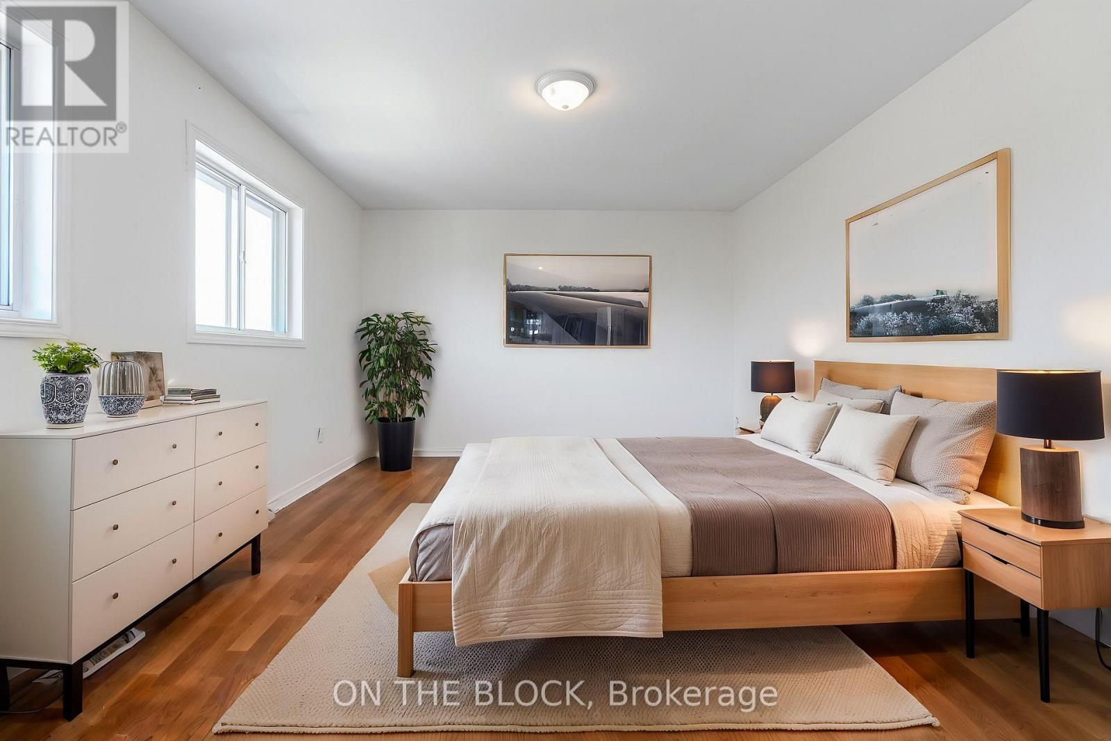 A bedroom with a bed, nightstand, and dresser.