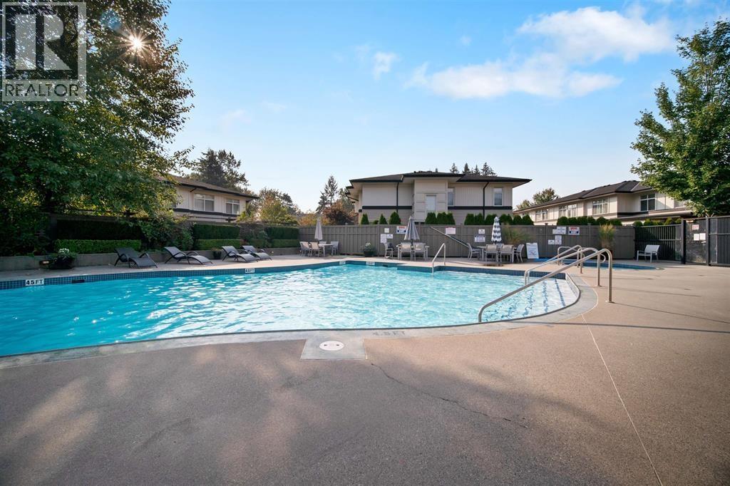 A swimming pool in a residential area with houses in the background.