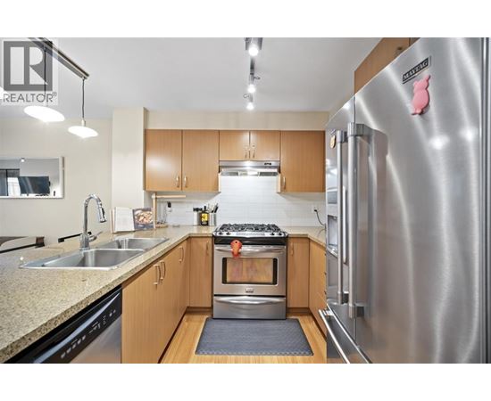 A modern kitchen with wooden cabinets and stainless steel appliances.