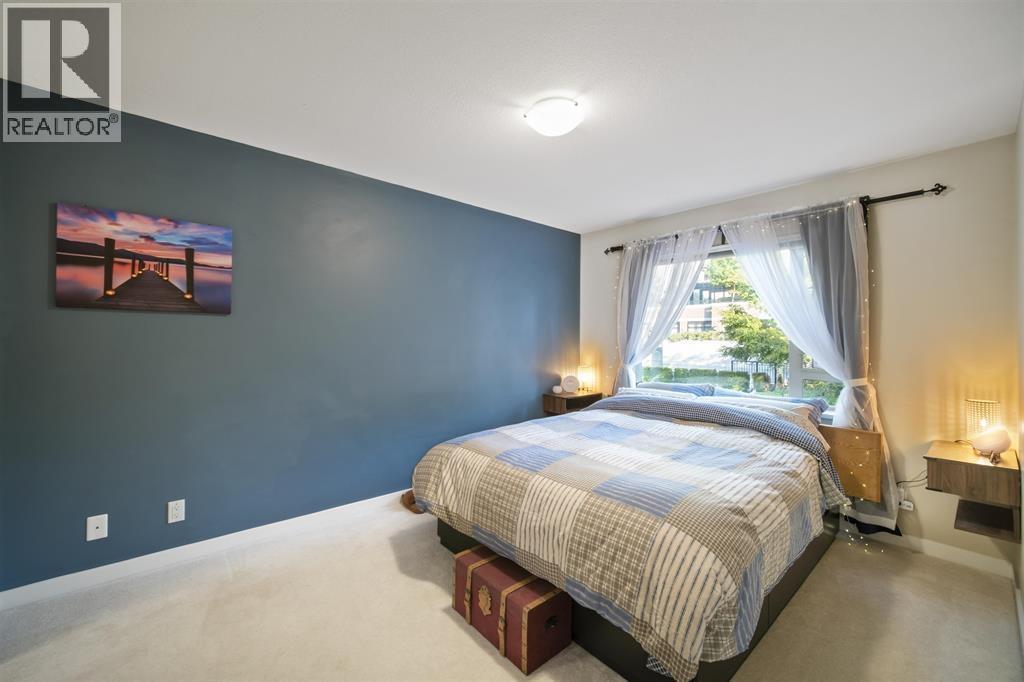 A bedroom with a bed, nightstands, and a painting on the wall.