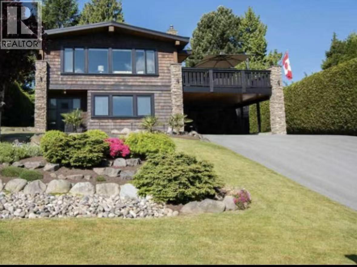 A house with a well-maintained lawn and a rock garden in front.
