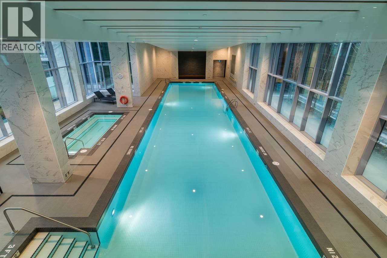 A large indoor swimming pool with a glass bottom.