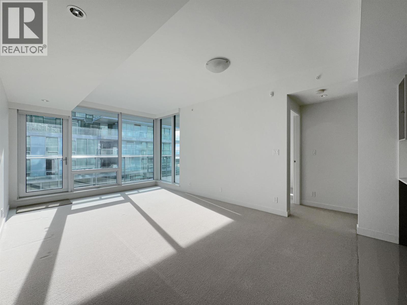A spacious room with a large window and a door.