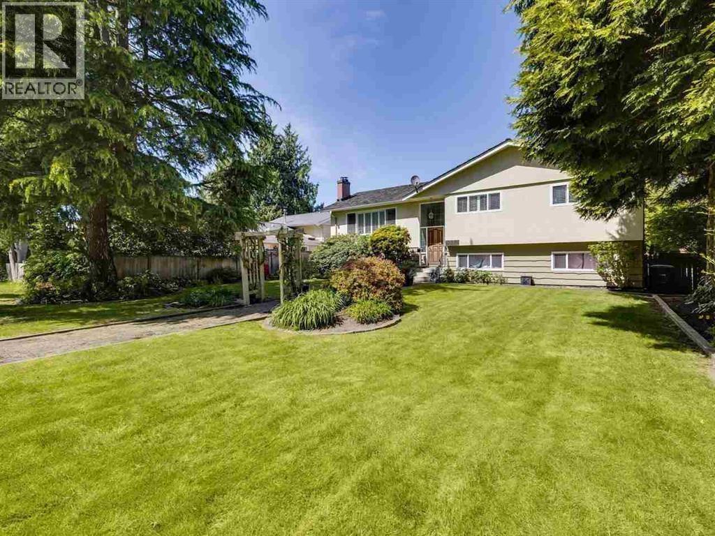 A well-maintained lawn in front of a house with a realtor sign.