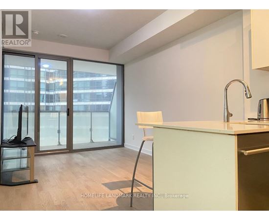 A kitchen with a sink, a chair and a window with a view of a city.