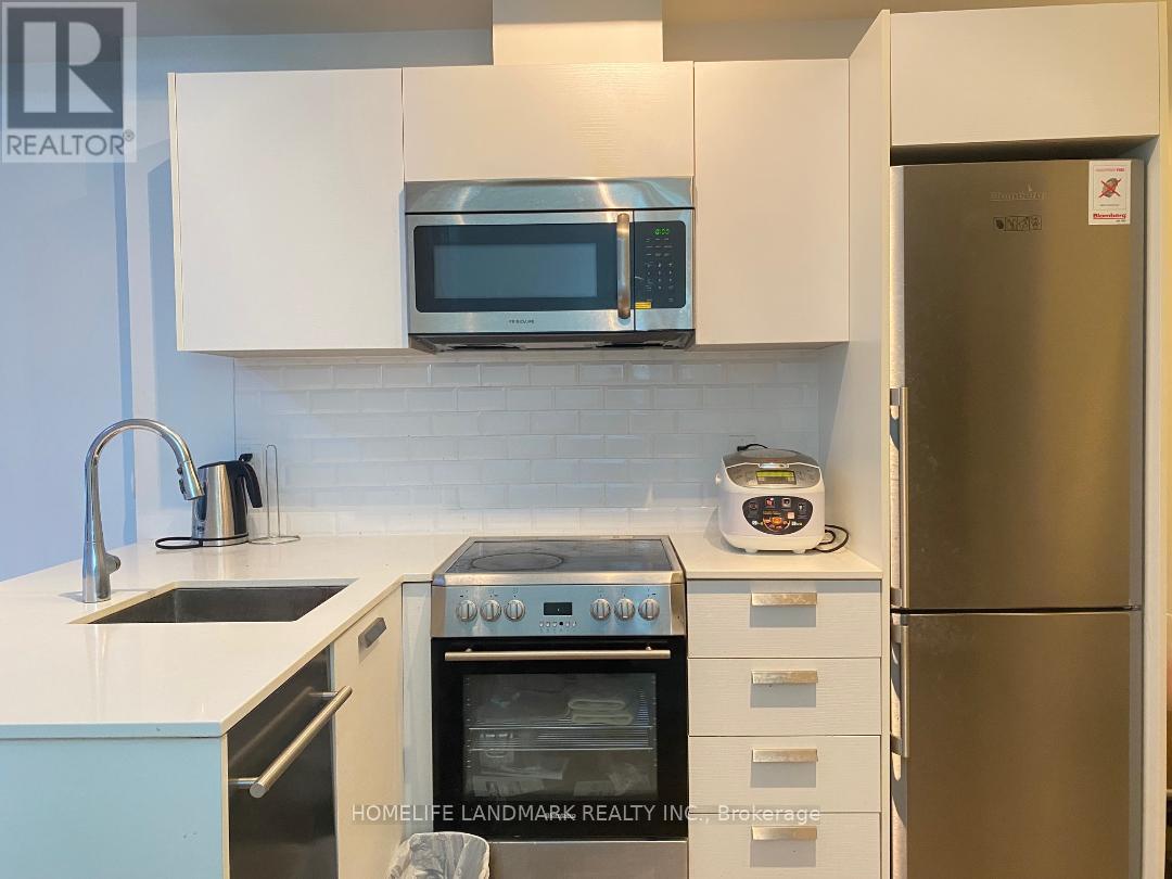 A kitchen with a stainless steel refrigerator and white cabinets.
