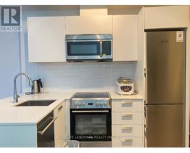 A kitchen with a stainless steel refrigerator and white cabinets.