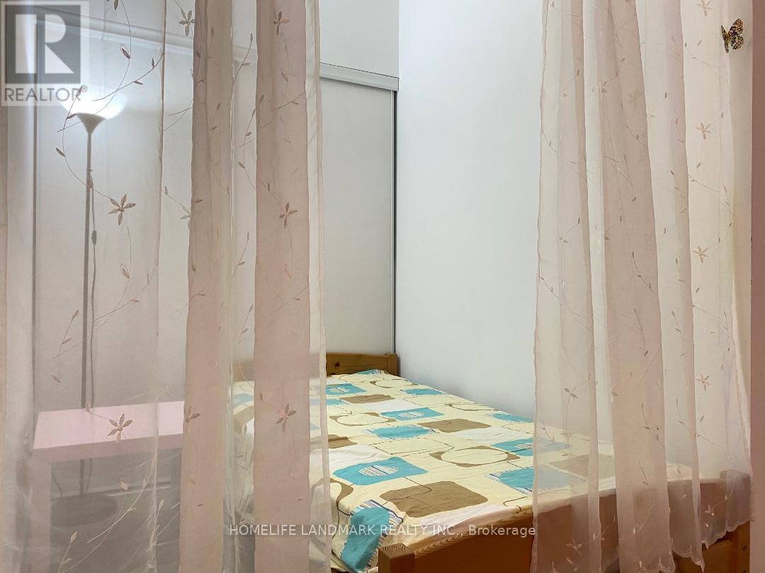 A bedroom with a bed covered in a patterned bedspread and curtains with a butterfly design.