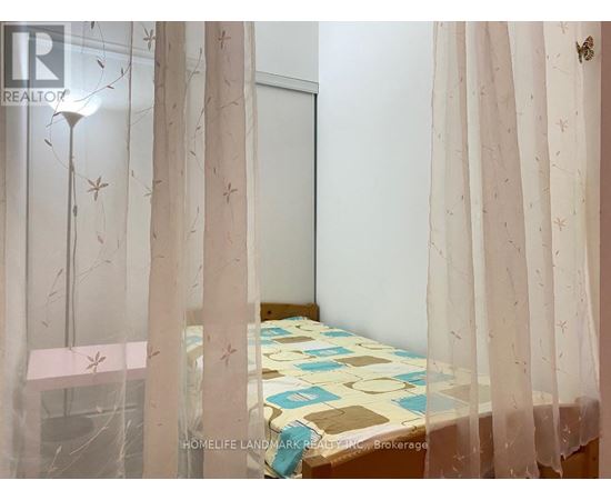 A bedroom with a bed covered in a patterned bedspread and curtains with a butterfly design.