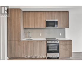 A kitchen with wooden cabinets and a microwave above the sink.