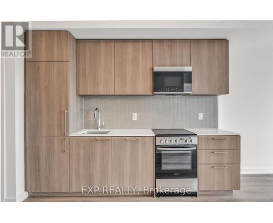 A kitchen with wooden cabinets and a microwave above the sink.