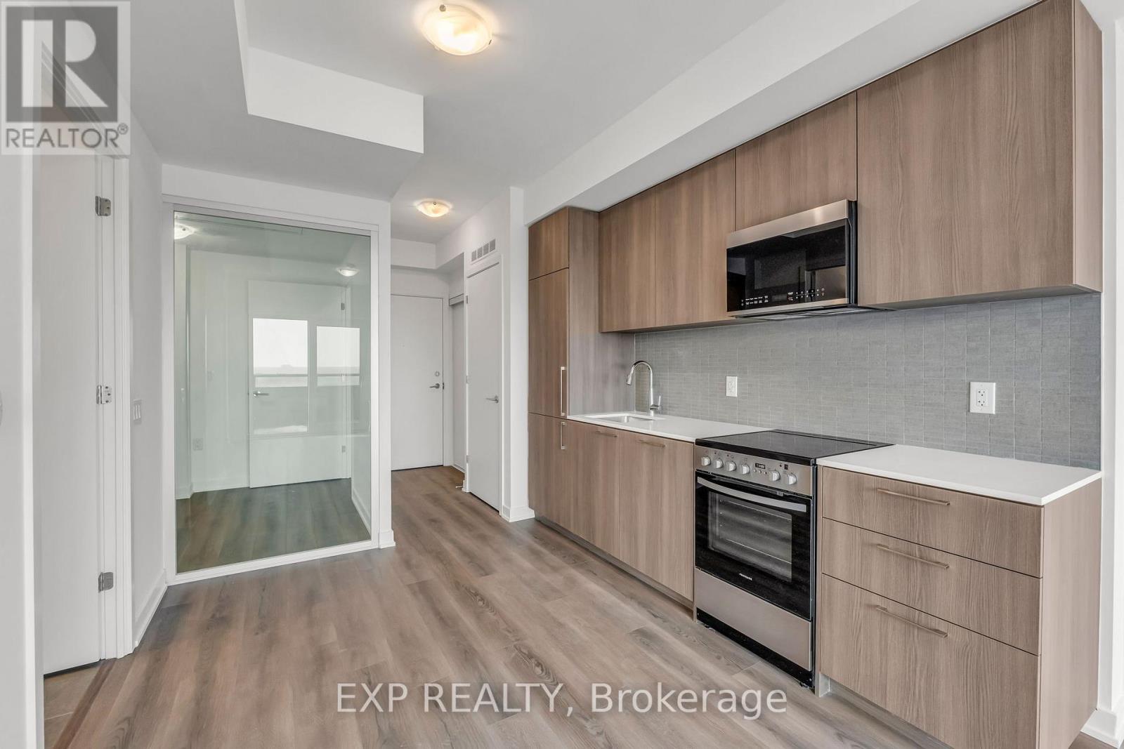 A kitchen with wooden cabinets and a stainless steel oven.