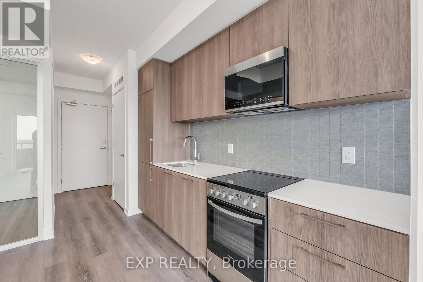 A kitchen with wooden cabinets and a black stove top oven.