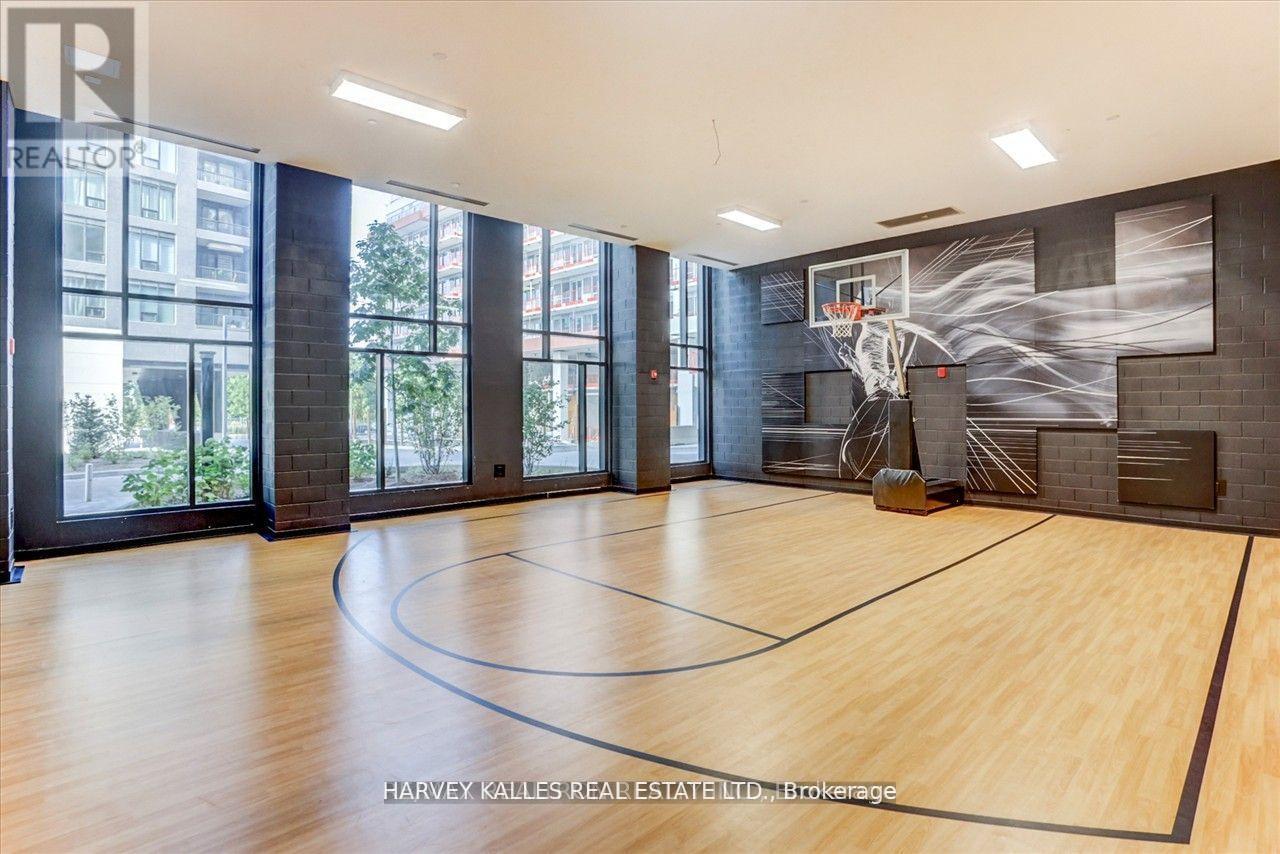 A basketball court in a spacious room with a mural on the wall.