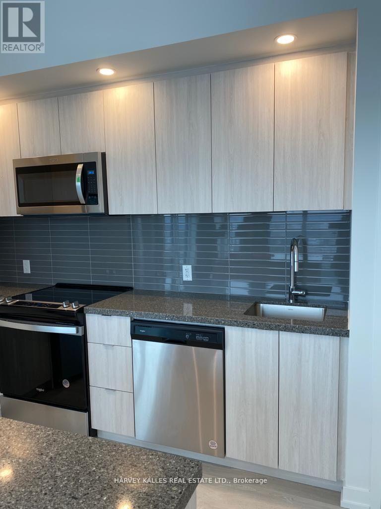 A modern kitchen with white cabinets and stainless steel appliances.