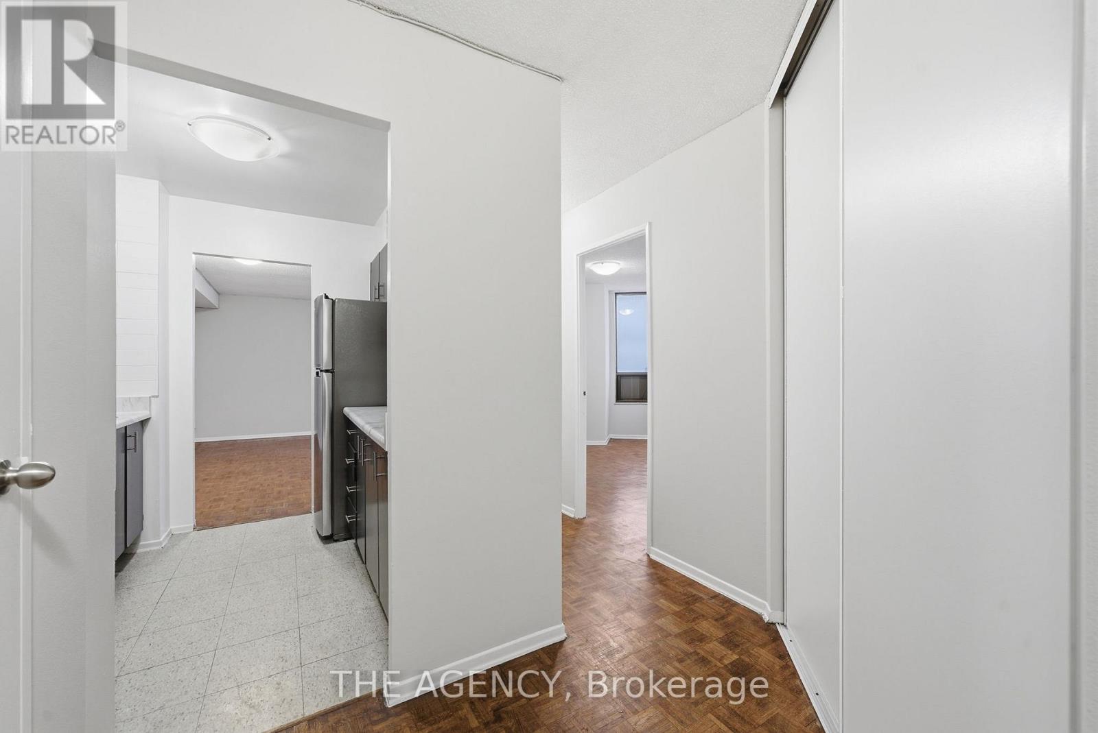 A hallway with white walls and a tiled floor.