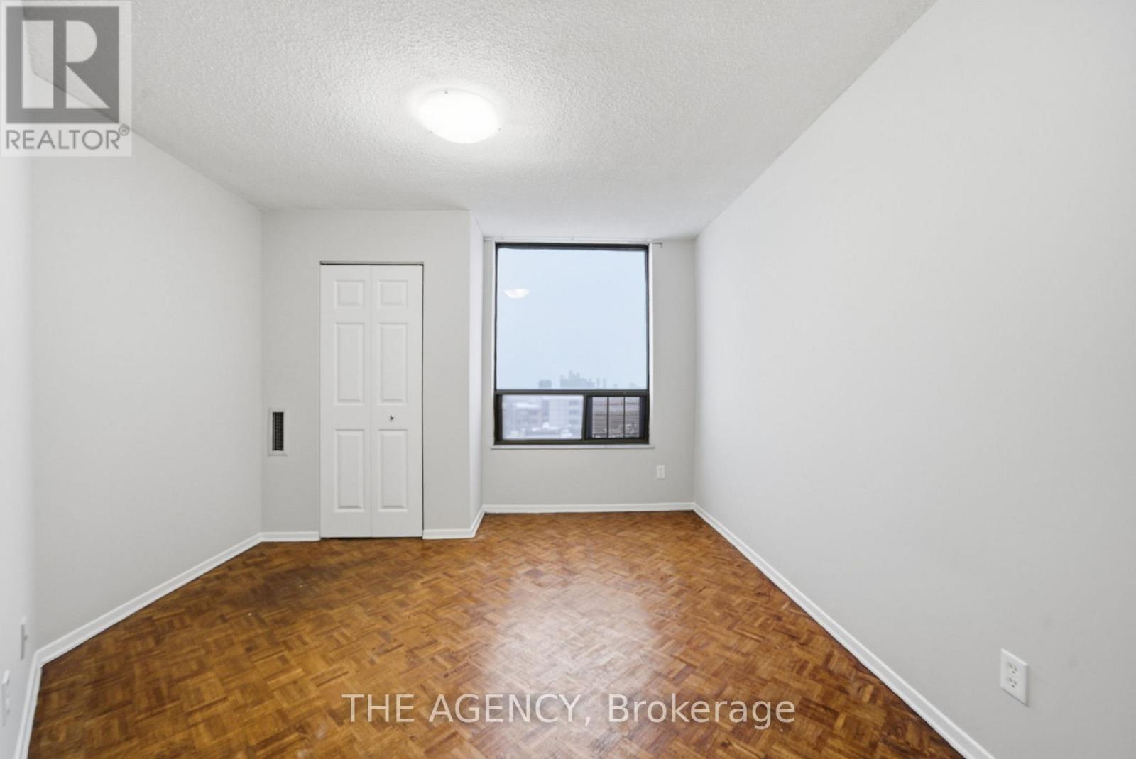 A room with a door and a window with a view of a building.