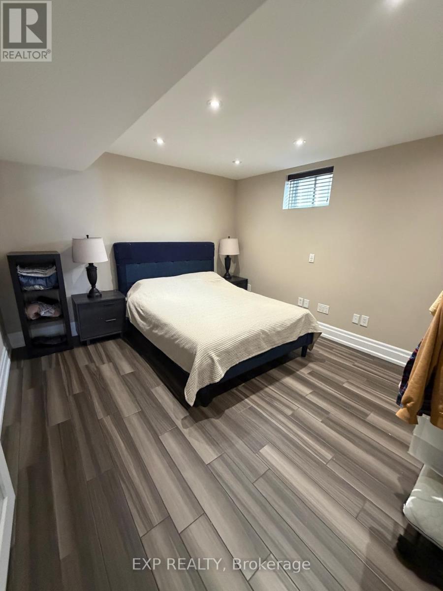 A bedroom with a bed, nightstands, and a window.