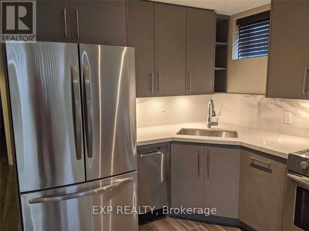 A kitchen with a stainless steel refrigerator and cabinets.