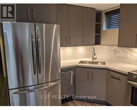 A kitchen with a stainless steel refrigerator and cabinets.