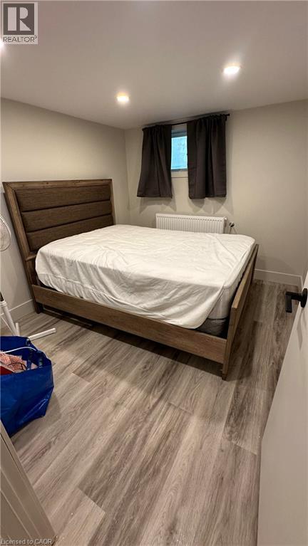 A bedroom with a bed, nightstand, and window.